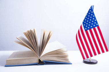 Kürsüde Amerikan bayrağı ve beyaz arka planda kitap