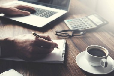 Ofis masasında bilgisayar dizüstü bilgisayarıyla çalışan iş adamı