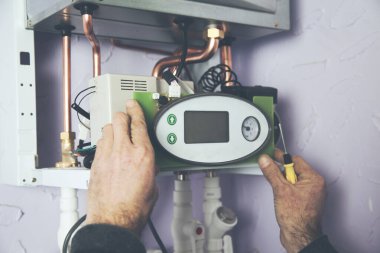 Verimli otomatik ısıtma sistemi için termostatı ayarlayan mühendis