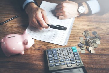 Hesap makineli adam para sayıyor ve evde notlar alıyor.