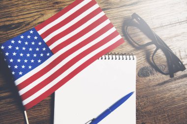 Masada Amerikan bayrağı ve gözlüğü olan not defteri.