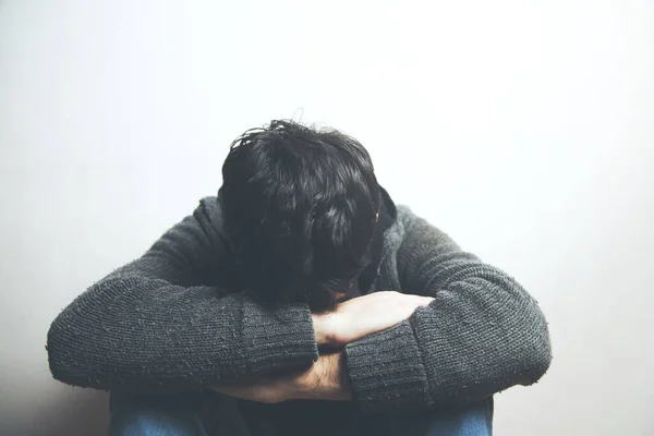 とても悲しい若い男が床に座って泣き顔を隠して — ストック写真