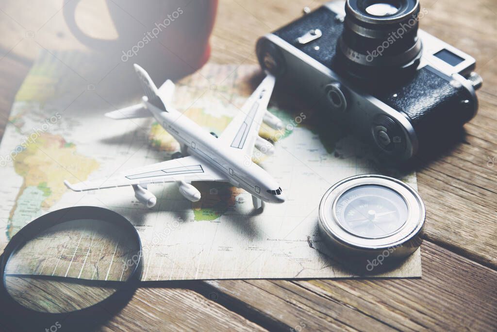 Travel objects on map on  wooden table