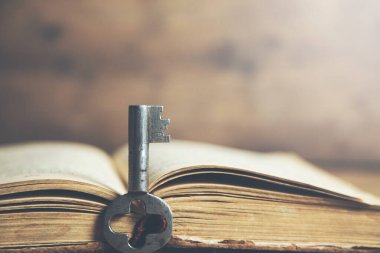 Eski bir masa üzerinde eski bir kitap ve anahtar.