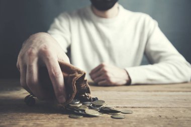 Ahşap masa arkasında cüzdanı olan adam el sikkeleri