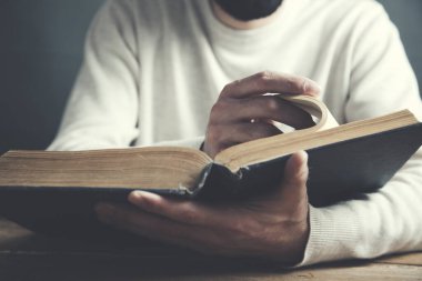 Masa arkasında kitap okuyan adam