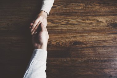 Erkek ve kadın el ele tutuşuyor. 