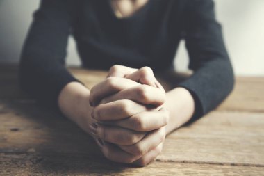 Masada oturan ve elini çapraz yapan bir kadın.