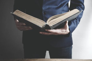 Karanlık arka planda kitap okuyan adam