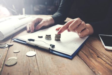 Kadın madeni para ve belgeleri masaya bırakıyor.