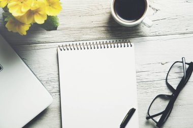 Not defteri ve klavye üzerinde kahve olan.