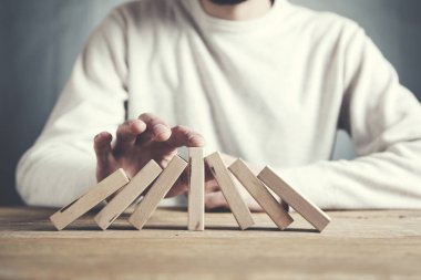 İş adamı masaya tahta küpler yapıyor.