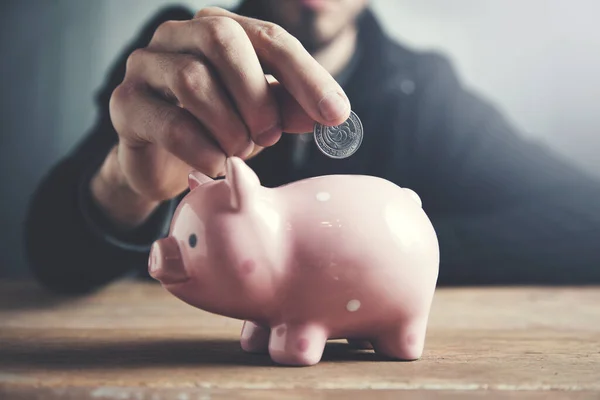 Man Putting Coin Piggy Bank — Stock Photo, Image