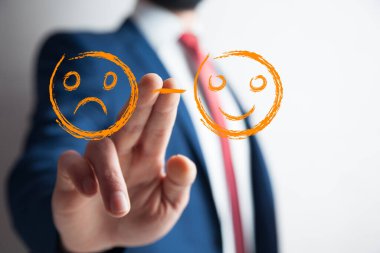 Erkek eli üzgün ve mutlu yüz düğmesine basar