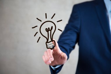 Ekranda el çizimi ampule dokunan işadamı