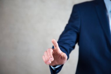 İş adamı koyu arkaplanda dokunmatik ekrana tıklıyor