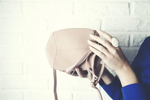 Woman hand  fashion bag on brick wall background