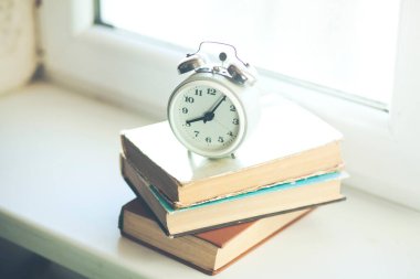 Penceredeki kitaplarda geri alarm saati
