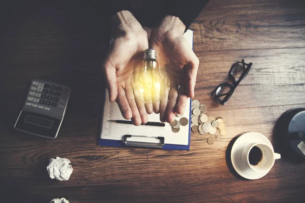 man hand light bulb or idea and stationary on table