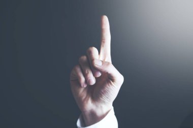 Erkek eli arka planda işaret parmağına dokunuyor.