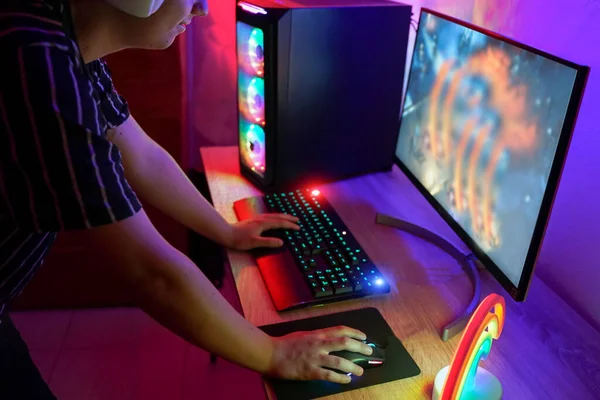 Bluetoot kulaklıkla video oyunu oynayan genç bir oyuncu. Oyuncu evde oyun oynamak için bilgisayarı kullanarak konsantre oldu. Yeni teknoloji oyun trendleri ve eğlence konsepti. El ve fareye odaklan - Resim