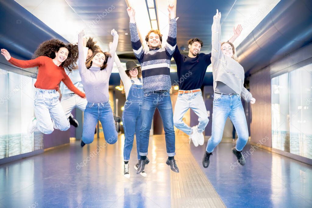 Happy millennials friends jumping indoor in the metro. Young students having fun together laughing together. Youth, lifestyle, team, multiracial, friendship concept - Image