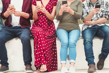 Gençler video izleyip, akıllı telefonlardan sosyal güvenlik numaralarını izliyorlar. Yeni teknoloji eğilimlerine bağımlılık. Gençlik, teknoloji, sosyal ve arkadaşlık kavramı. Ellere odaklan. Resim