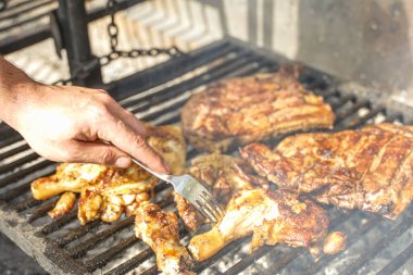 Boş zaman, yemek, insanlar ve tatil konsepti. Barbekü ızgarasında et pişiren adam, açık havada yaz.