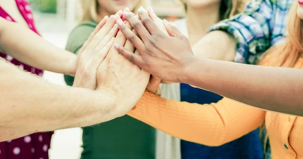 Young people putting their hands together. Friends with stack of hands showing unity and teamwork . Image