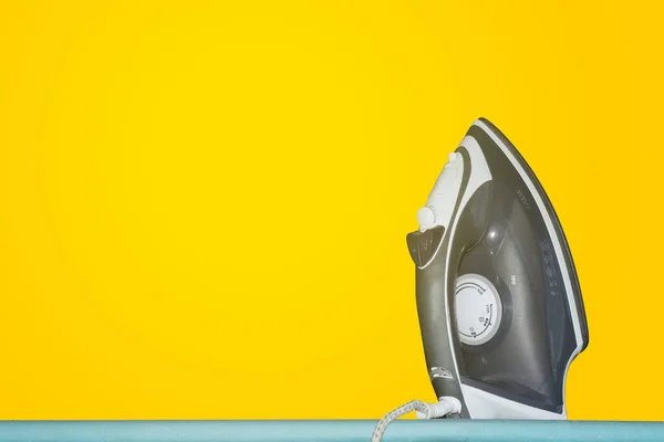 iron on a table on a yellow background, isolation