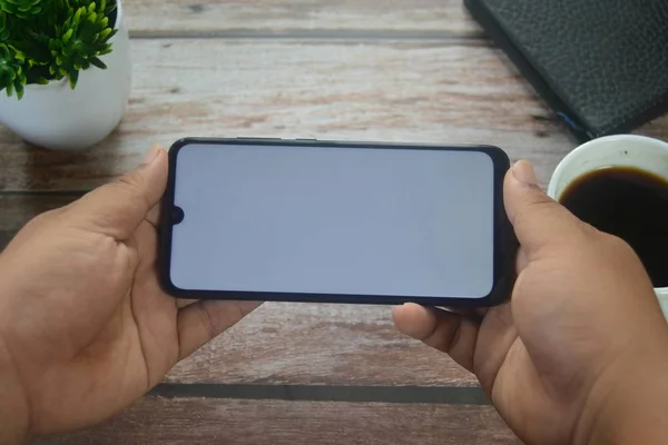 Özperspektif akıllı telefon Anahtar renk ekranı için yeşil ekranı olan bir adamın ellerinde.