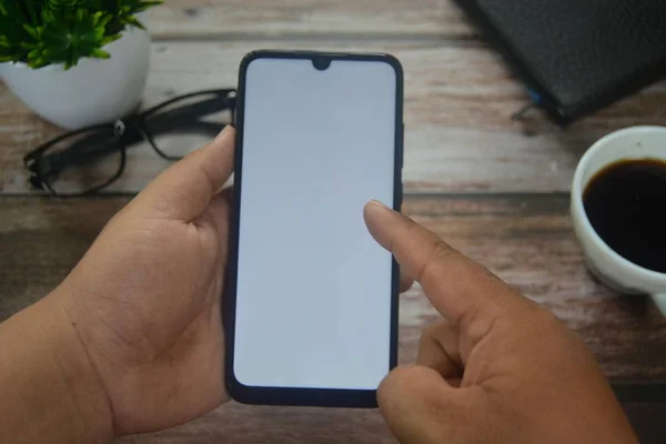 Eller boş ekranda ahşap masadaki akıllı telefondan.