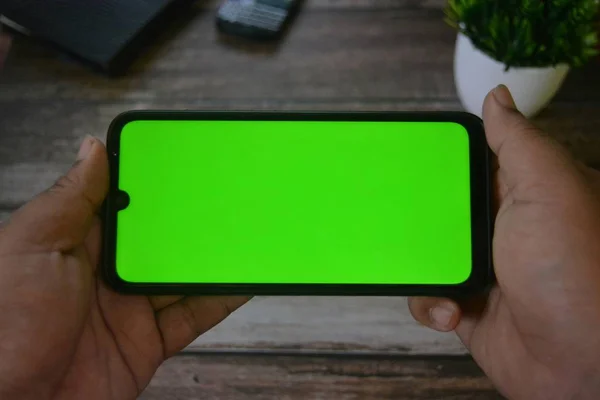 Self Perspective smartphone In the hands of a man with green screen for key chroma screen.