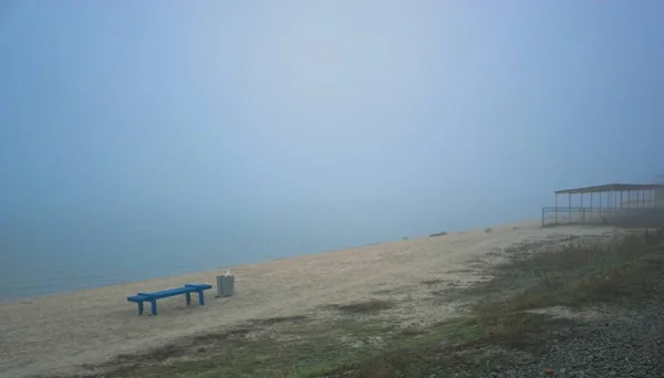 Fim da terra na praia com um banco e um dossel — Fotografia de Stock