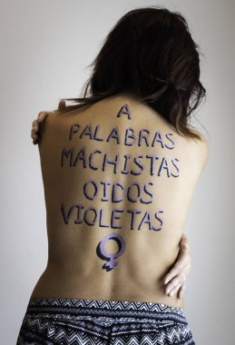 Empowered woman with feminist motto painted on her back clipart