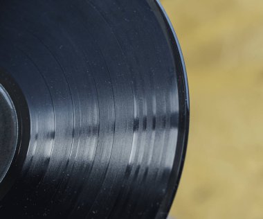 Close-up of a vinyl record on a golden background vintage, retro, old style concept