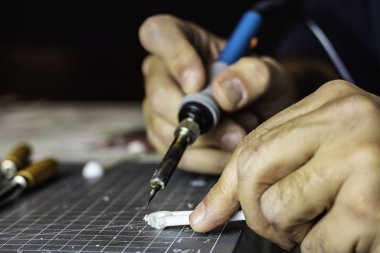 Aletlerle çalışan bir adamın ellerine yakın çekim