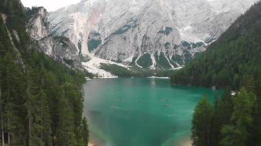 İtalya 'nın kuzeyindeki Alpler' in insansız hava aracı görüntüsünden çekim yapmak gri-yeşil göl geyikleri, eriyen buzullar, bulutlu gökyüzü. İtalya 'da yaz, yeşil ormanlar.