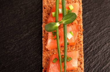 Çavdar ekmekli somon parçaları, yeşil soğanlı ve taze filizli..