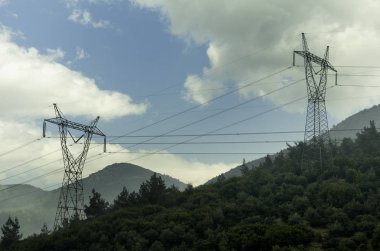 Ormanı kesen elektrik direkleri. Dağdaki elektrik hatları