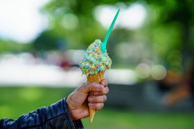 Dondurma külahı tutan adam. Elinde gökkuşağı parçacıkları olan dondurmanın ayrıntıları