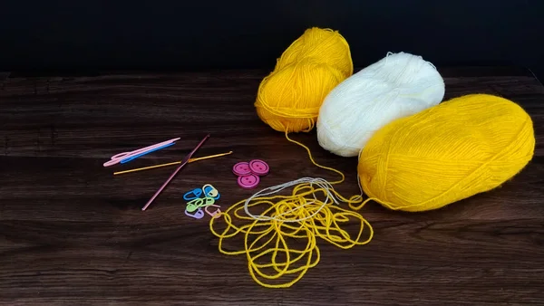 Вязание белых и желтых шариков с вязанием аксессуаров  . — стоковое фото