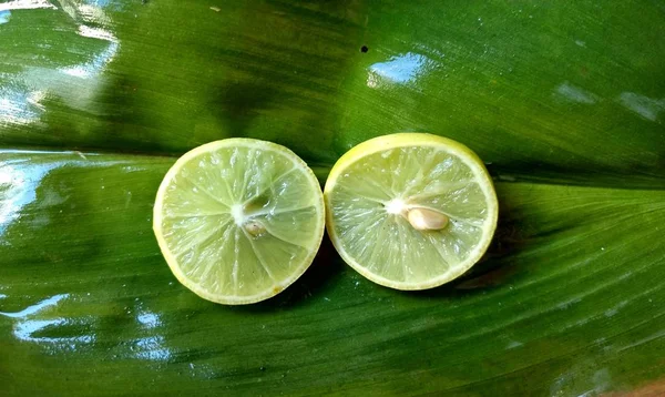 As partes de limões em uma folha verde. conceito de comida tropical — Fotografia de Stock