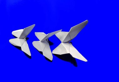 Mavi arka planda beyaz kağıt kelebekler. dekoratif konsept