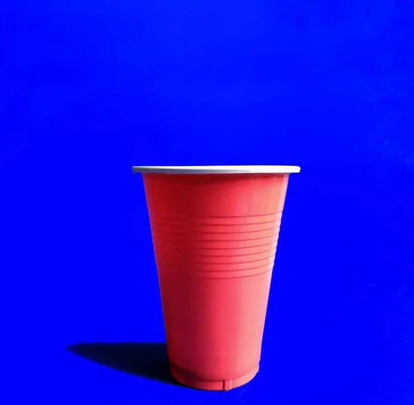 Vidro vermelho sobre fundo azul. jogo de cerveja pong. conceito de partido — Fotografia de Stock