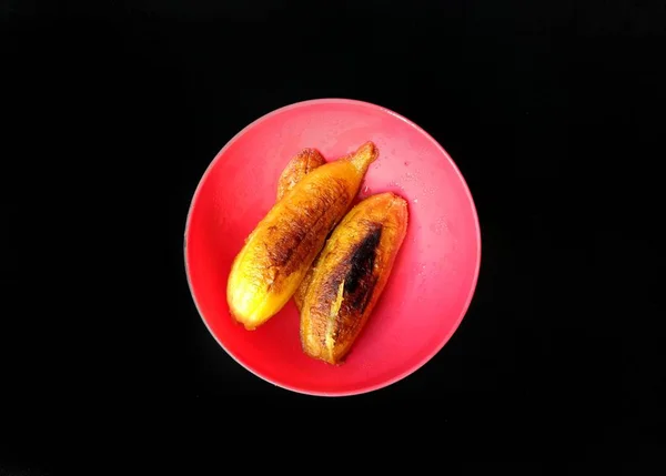 Bananas fritas na placa vermelha com fundo preto. comida típica da Guatemala — Fotografia de Stock