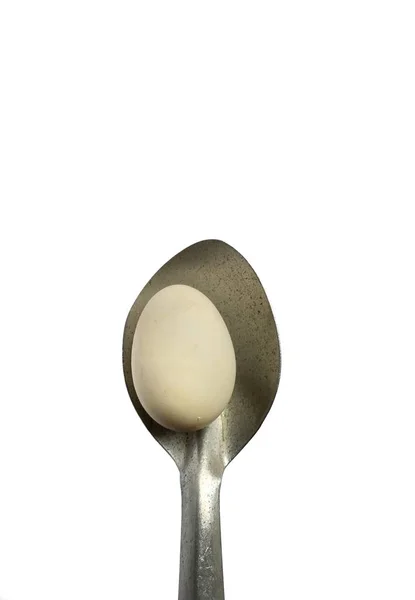 Łyżka trzymająca organiczne jajko na białym tle. zdrowa koncepcja żywności — Zdjęcie stockowe