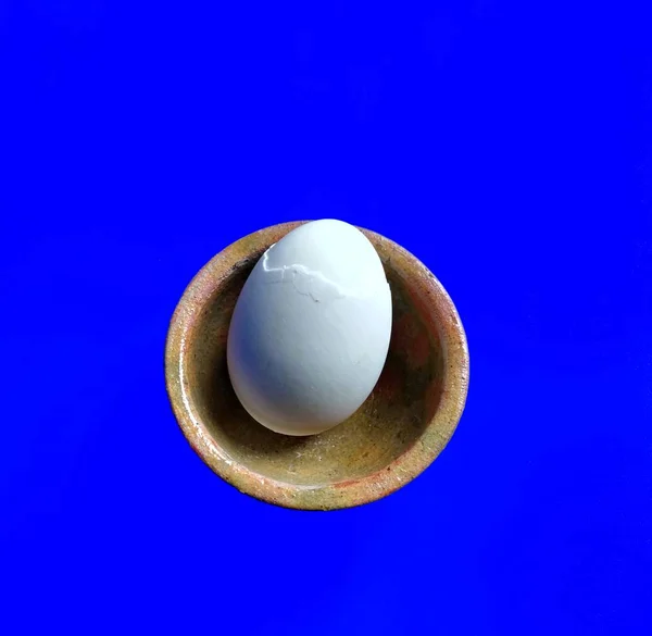 Boiled egg on clay bowl on blue background. healthy food concept — ストック写真