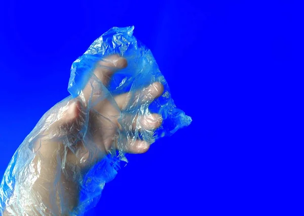 Hand with plastic bag on blue background. pollution concept — Stock Photo, Image