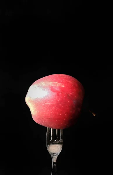 Tenedor en una manzana sobre fondo negro. concepto de alimentos saludables — Foto de Stock